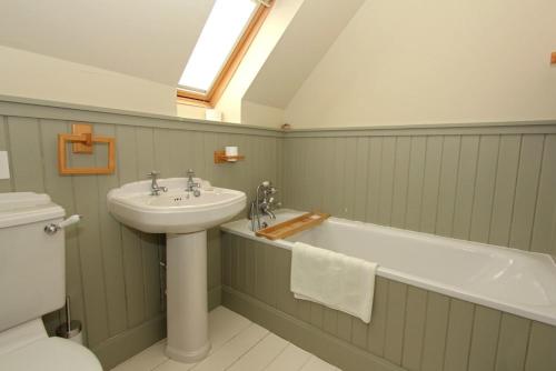 a bathroom with a sink and a bath tub and a toilet at Saltwinds in Carbost