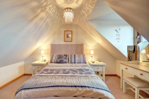 a bedroom with a bed with two night stands and two tables at St Clements View in Rodel