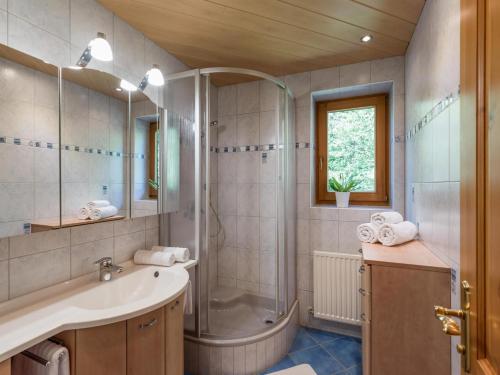La salle de bains est pourvue d'une douche, d'un lavabo et d'une baignoire. dans l'établissement Appartement Melodie, à Scheffau am Wilden Kaiser