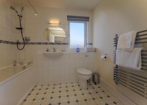 a bathroom with a tub and a toilet and a sink at Little Glenforsa in Salen