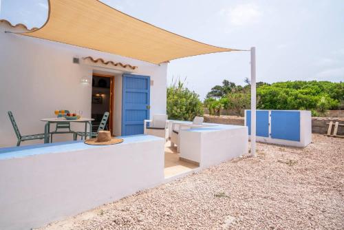 a patio with a blue door and a table at Cas Saliners - Ses Illetes in La Savina