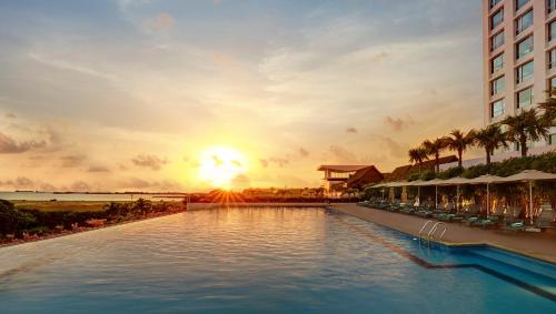 a view of a pool at a resort at sunset at Holiday Inn Melaka by IHG in Melaka