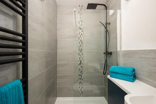 a bathroom with a shower with a blue towel at Am Bothan in Lochearnhead
