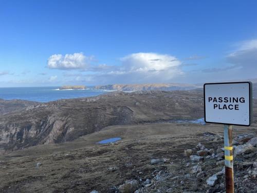a sign on the side of a mountain with the ocean at Spindrift in Brenish