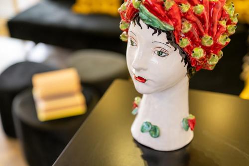 a statue of a woman with a red wig on a table at L'Hotel in Rimini