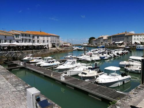 Un tas de bateaux sont amarrés dans un port dans l'établissement Appartement élégant avec vue sur le port, à Saint-Martin-de-Ré