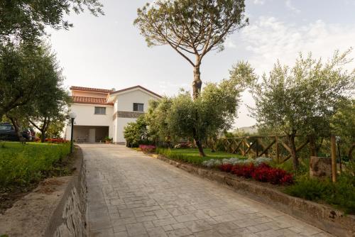 uma passarela em frente a uma casa com árvores e flores em La Gesina B&B em Piano di Sorrento