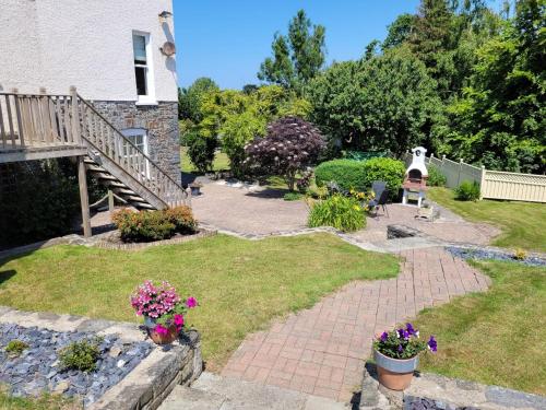 a garden with a staircase and flowers in a yard at Llys Bach Apartment at Llys Aeron in Aberaeron