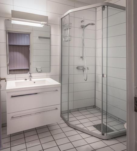 a bathroom with a sink and a glass shower at Bergo Leiligheter in Beitostøl