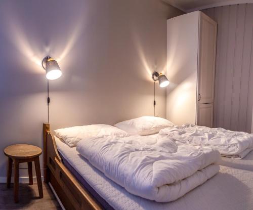 a bedroom with a large bed with two lights on it at Bergo Leiligheter in Beitostøl