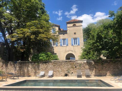 un bâtiment avec une piscine en face d'un mur dans l'établissement Les Dames de Saint Florent, à Saint-Florent-sur-Auzonnet