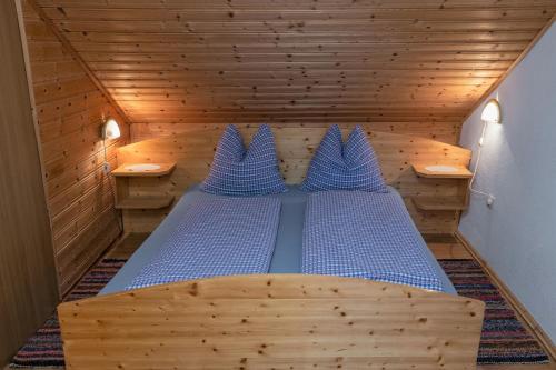 a large wooden bed in a wooden room at Almhütten Sonnblick & Almfried in Sonnenalpe Nassfeld