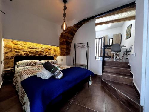 um quarto com uma cama com um edredão azul e escadas em 58 Gradini di Girgenti em Agrigento