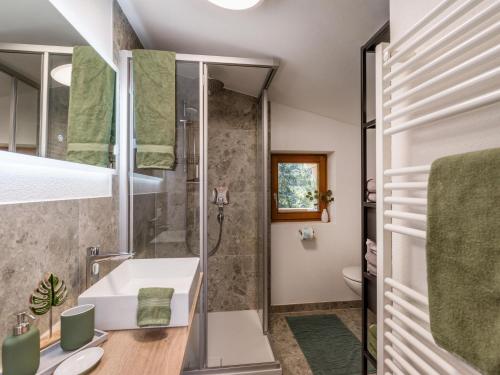 La salle de bains est pourvue d'un lavabo et d'une douche. dans l'établissement Appartment Jaggi, à Hopfgarten im Brixental