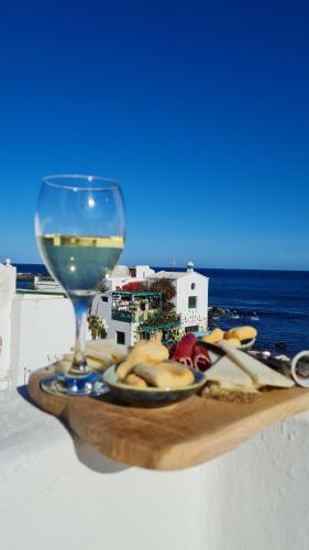 a plate of food and a glass of wine at Apartamento Jameo in Punta Mujeres