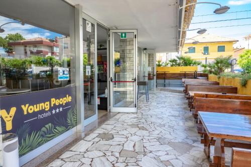 un ristorante con tavoli e panche all'esterno di Hotel Morfeo - Young People Hotels a Rimini