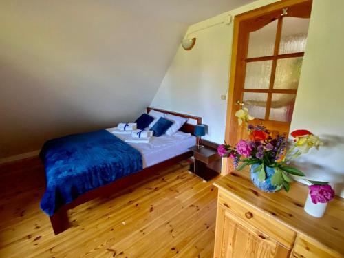 a bedroom with a bed and a vase of flowers at Brzozowy Chillout in Dubeninki