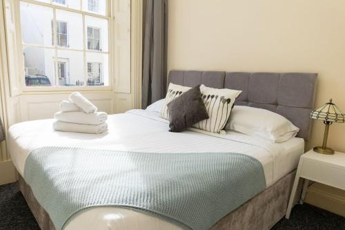 a bedroom with a bed with towels on it at K Suites - Montpellier Apartments in Cheltenham