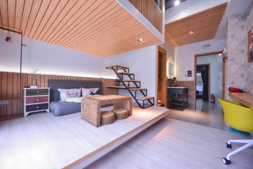 a room with a bed and a desk and a ladder at Min-sheng Art homestay in Tainan