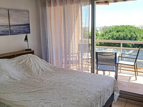 um quarto com uma cama e uma varanda em Appartement Bormes-les-Mimosas, 3 pièces, 4 personnes - FR-1-610-73 em Bormes-les-Mimosas