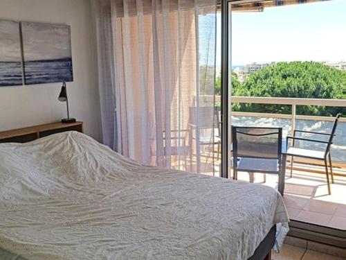 une chambre avec un lit et un balcon dans l'établissement Beau T3 3* à 50m de la plage avec piscine, tennis et parking. - FR-1-610-73, à Bormes-les-Mimosas