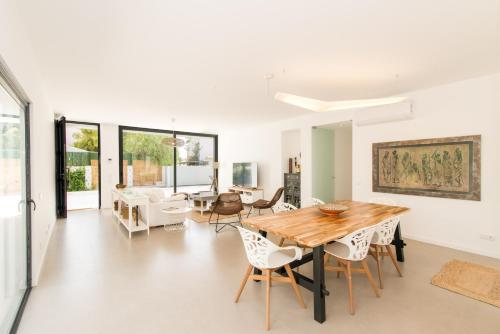 a dining room with a wooden table and chairs at Villa 91 by ALGARTUR in Tavira