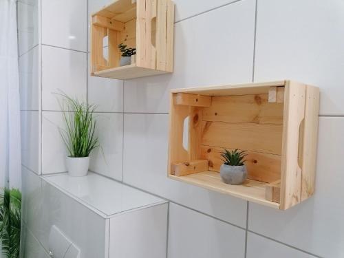 baño con armarios de madera y macetas en M-OASE Feeling Design I Küche I Netflix I Balkon, en Brunswick