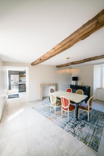 une cuisine et une salle à manger avec une table et des chaises dans l'établissement Gites Saint Martin - Le Couvent et sa piscine, à Grosville