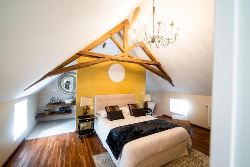 a bedroom with a large bed in a attic at Gites Saint Martin - Le Couvent et sa piscine in Grosville