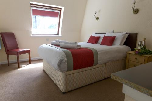 A bed or beds in a room at Loch Ness Drumnadrochit Hotel