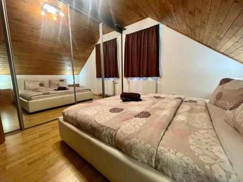 a bedroom with a large bed and a mirror at Margaret Apartment in Balatonkeresztúr