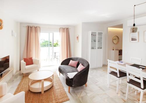 ein Wohnzimmer mit einem Stuhl und einem Tisch in der Unterkunft Balcón del Mar Estepona in Estepona
