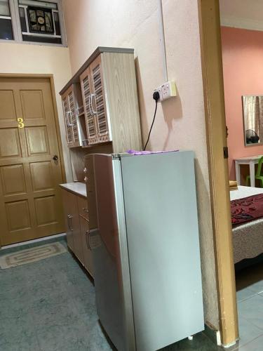 a kitchen with a refrigerator in a room at Bilik Harian Pengkalan Chepa in Pengkalan Cepa