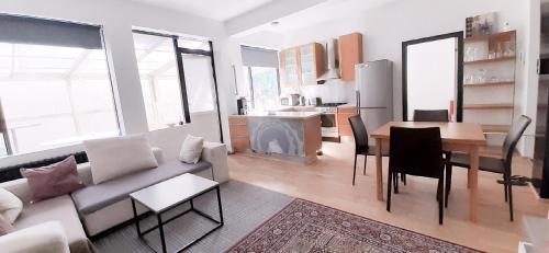 a living room with a couch and a table and a kitchen at Reykjavik Antique Rentals in Reykjavík