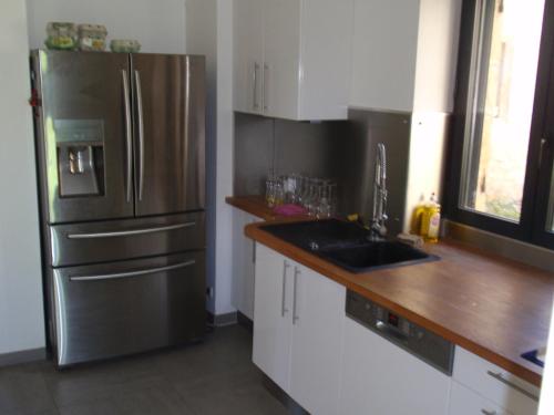 une cuisine avec un réfrigérateur en acier inoxydable et un évier dans l'établissement Villa Meysset, à Sarlat-la-Canéda