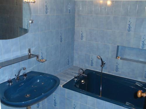 La salle de bains bleue est pourvue d'un lavabo et d'une baignoire. dans l'établissement Villa Meysset, à Sarlat-la-Canéda