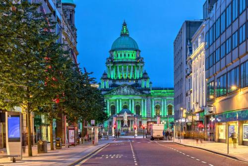 a building with green lights on a city street at Ramada by Wyndham Belfast in Belfast