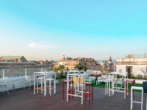 a patio with tables and chairs on a roof at NeapolitanTrips Hotel in Naples