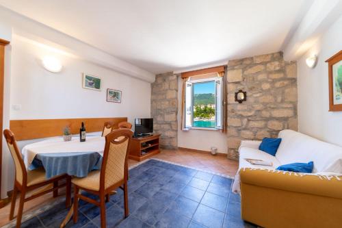 a living room with a table and a couch at Apartments Residence Astoria in Rab