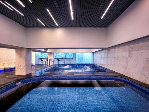 a large swimming pool in a building with a swimming poolvisor at Grand Mercure Jakarta Harmoni in Jakarta