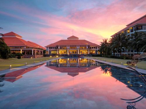 een resort met een zwembad voor een gebouw bij Pullman Danang Beach Resort in Da Nang