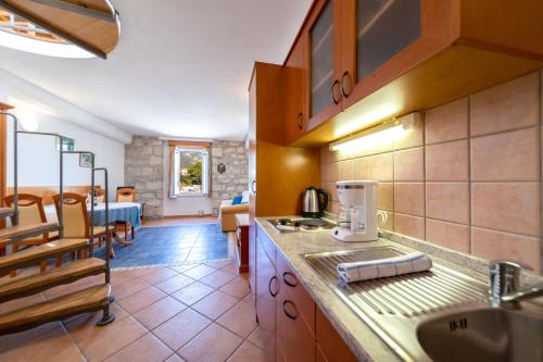 a kitchen with a sink and a counter top at Apartments Residence Astoria in Rab