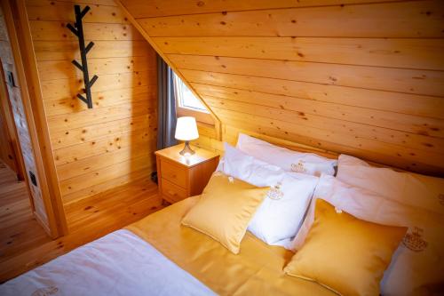 a bedroom with a bed in a log cabin at The Crown Lodge in Zlatibor