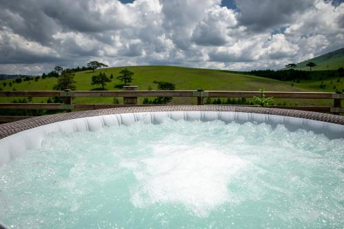 a hot tub with water in it in front of a field at The Crown Lodge in Zlatibor