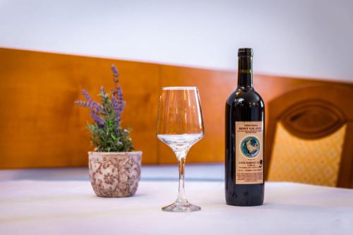 a bottle of wine and a glass on a table at Apartments Residence Astoria in Rab