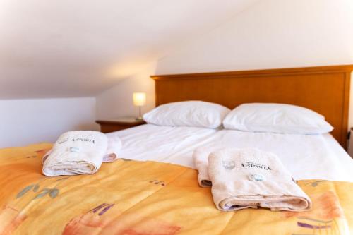 a bedroom with a bed with towels on it at Apartments Residence Astoria in Rab
