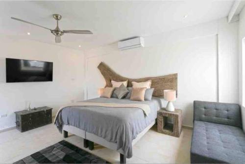 a bedroom with a bed and a tv and a couch at Luxury Villa in Lowlands, Sea View in Lowlands