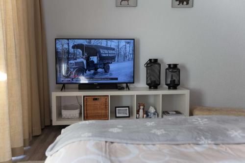 einen Fernseher auf einem weißen Stand in einem Schlafzimmer in der Unterkunft Grand Studio au centre de Crans in Crans-Montana