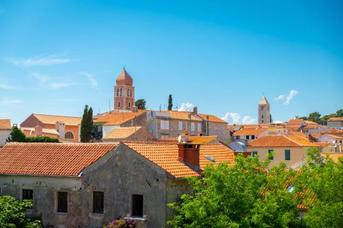 a view of a town with orange roofs at Apartments Residence Astoria in Rab