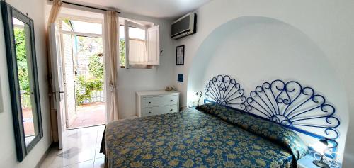 a bedroom with a bed with a blue and yellow bedspread at Hotel Poseidon in Lipari